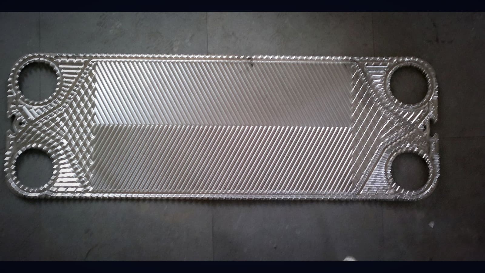A pressed stainless steel plate, its herringbone pattern catching the light