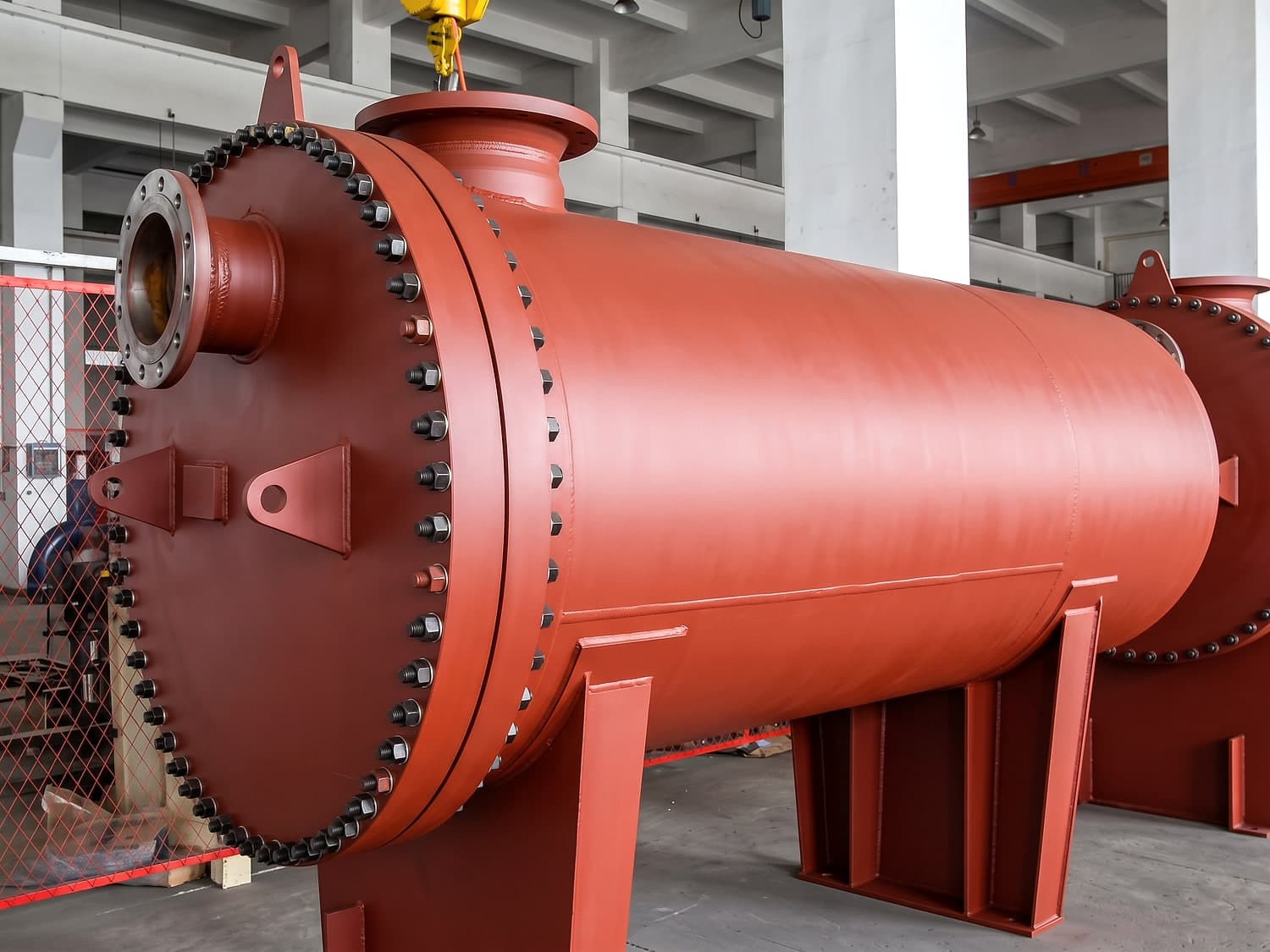 A larger plate & shell unit in red oxide primer, before the topcoat goes on. The studded head flange is the whole point of the construction: it opens to withdraw the pack, while the shell itself stays welded.