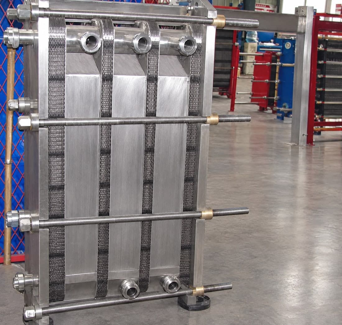 A stainless steel pasteuriser: the heating, holding and regeneration sections carried in one frame, built to hygienic standards.