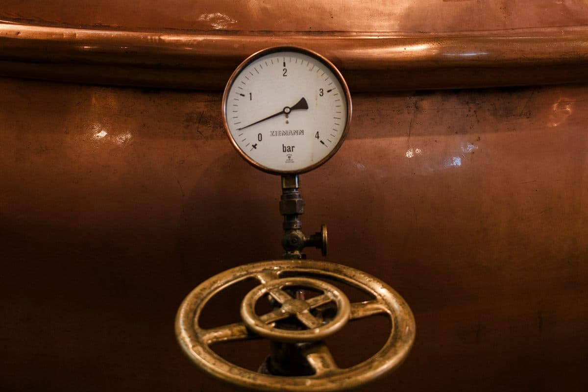Pressure gauge and brass valve handwheel on a copper brewhouse kettle