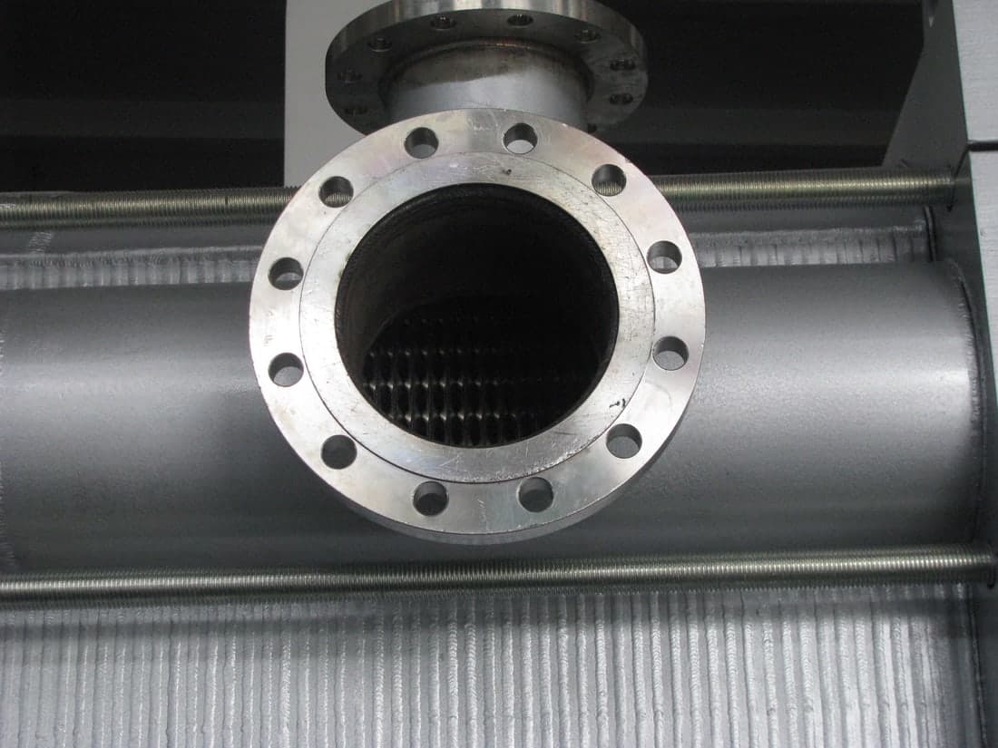 The port, flanged through the casing, with the welded plate pack visible behind it.