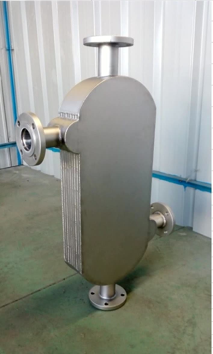 A finished fully welded unit: the plate pack sealed between its oval end covers, the pack edge visible down the flank, all four nozzles flanged.