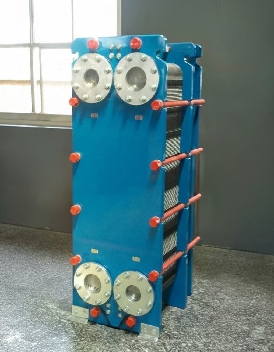 A gasketed unit closed on its frame: four flanged ports through the head plate, tie bars tensioned to the plate-pack dimension, and the plate pack visible along the side.