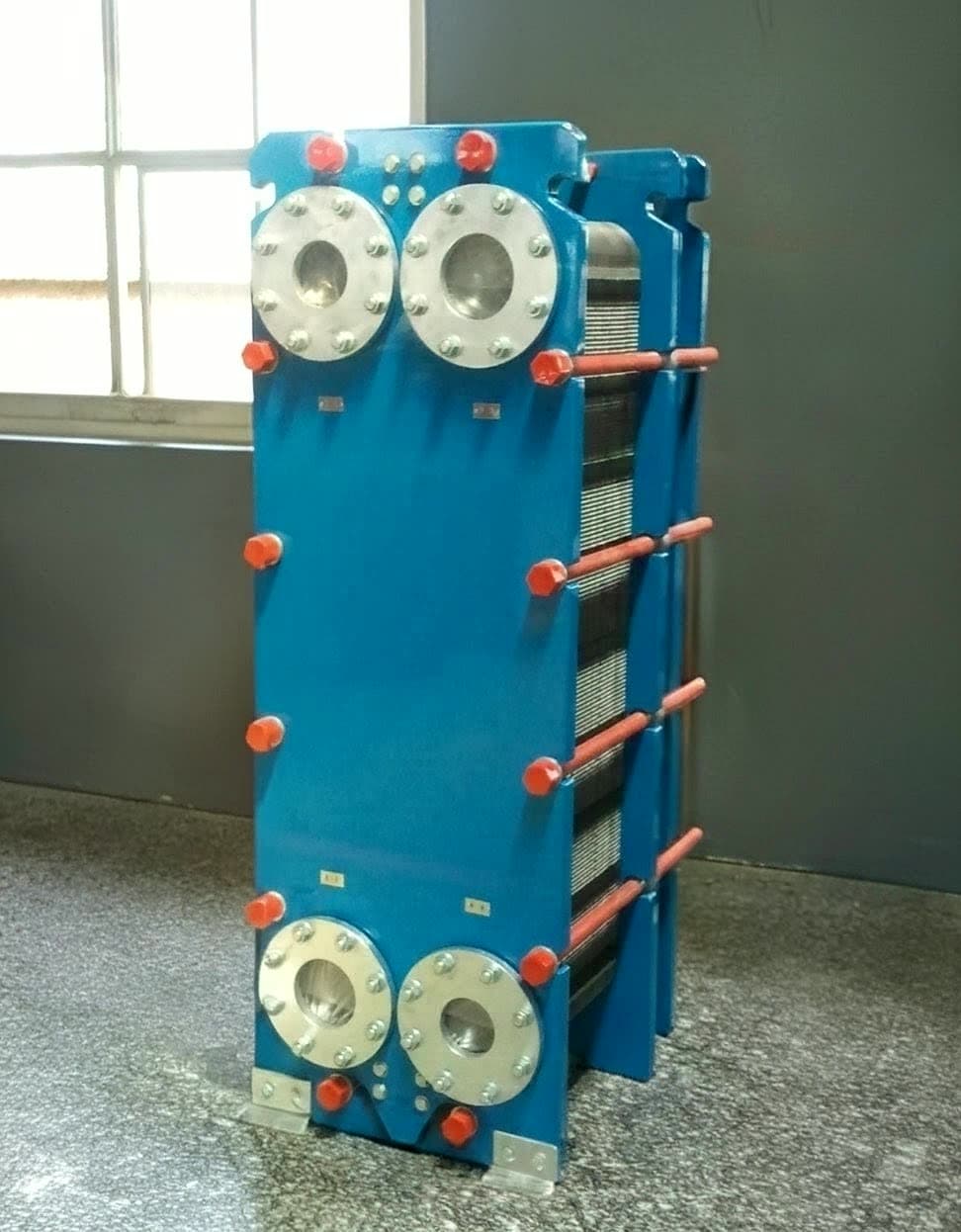 A gasketed plate heat exchanger closed on its frame, tie bars tensioned to the plate-pack dimension.
