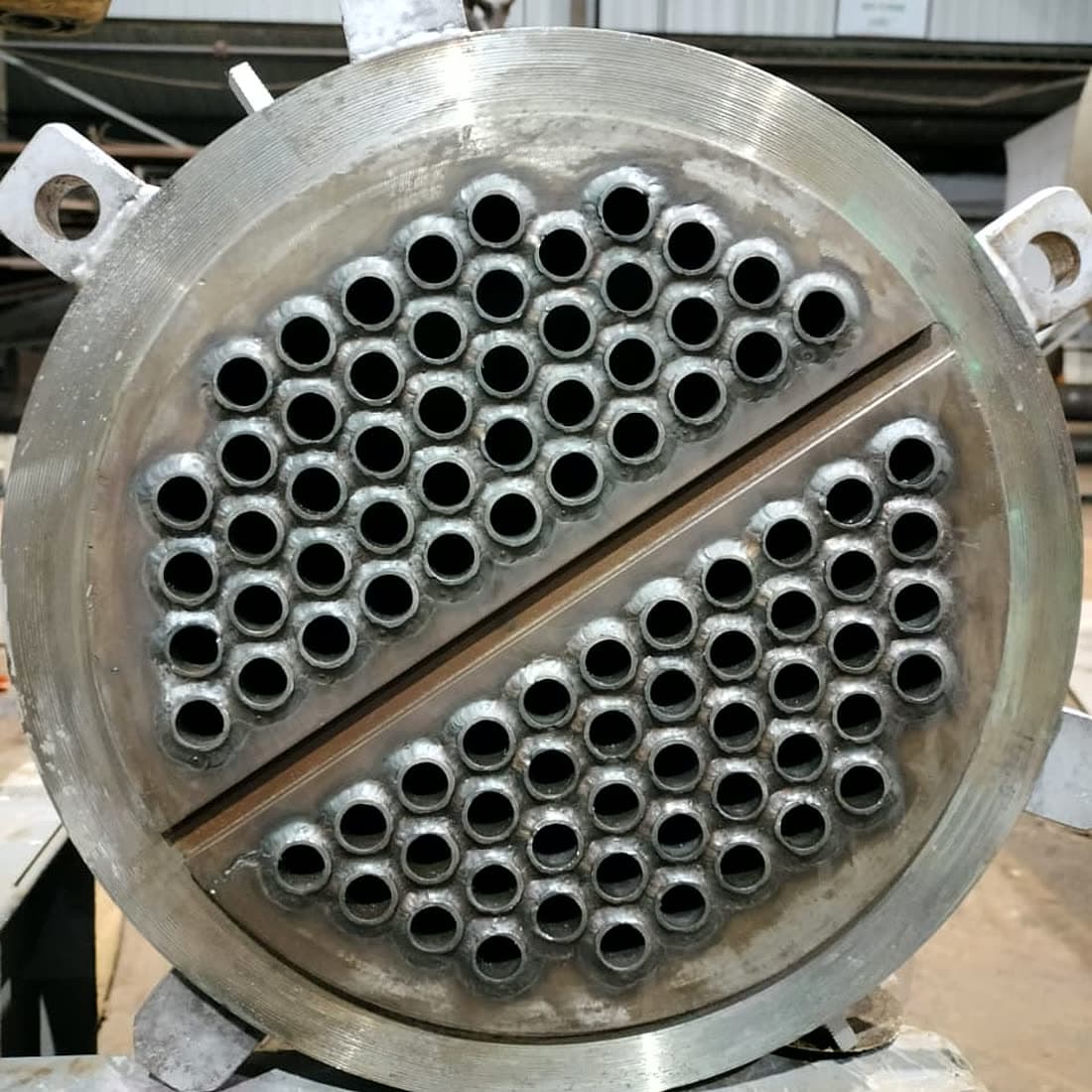 Finished tube sheet from a replacement bundle, tubes expanded and seal welded, with the pass partition groove machined across the face